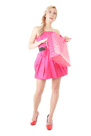 Young blonde woman with shopping bag looking up isolated over white backgroundの写真素材