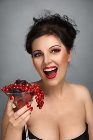 Happy smiling young woman with fruits cocktailの写真素材