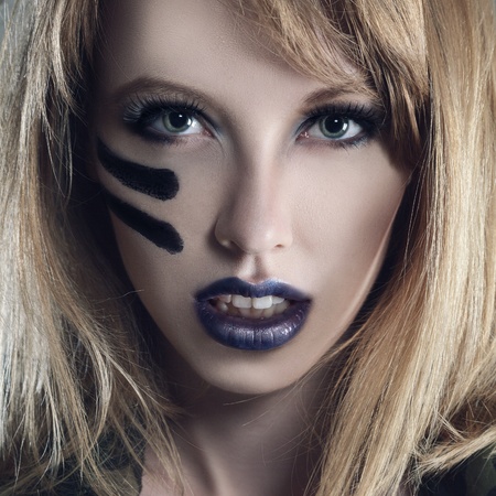 Beautiful young fashion woman with military style clothing and face paint make-upの写真素材