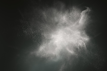 Abstract design of white powder cloud against dark backgroundの写真素材