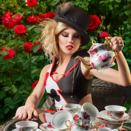 Young woman posing as magnificent card queen from wonderland at mystic tea-partyの写真素材