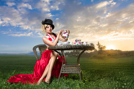 Young woman posing as magnificent card queen from wonderland at mystic tea-partyの写真素材