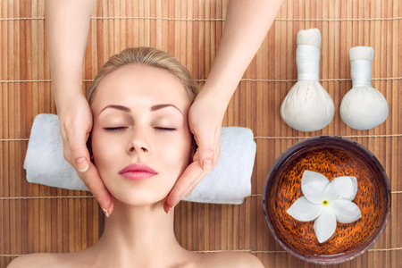 Young woman having head and face massage in spaの写真素材