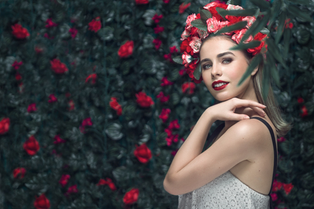 Summer woman portrait inspired by nature lifestyle. Beauty spring girl with blooming flowers wreath hairstyle on her head.の写真素材