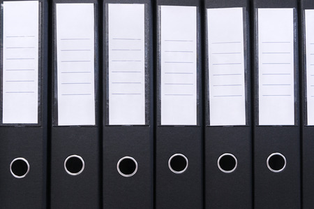 Office folders in a row with blank white labels on a coverの写真素材