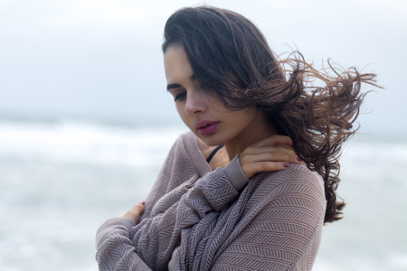 Moody Portrait of Young Woman Have Fun at the Sea Coast Beach with stormy clouds on the skyの写真素材