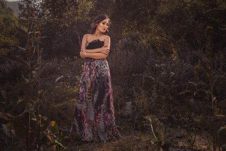 Beautiful young Asian woman exuding elegance as she strikes a pose amidst the forest's serene surroundings, enveloped in a palette of muted warm colors.の写真素材