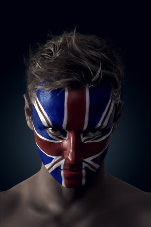 Soccer fan with Great Britain flag painted over face. Ideal for sports events and patriotic themes.の写真素材