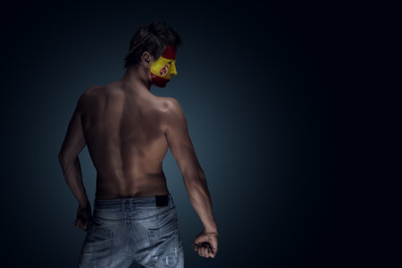 Soccer fan with Spain flag painted over face. Ideal for sports events and patriotic themes.の写真素材