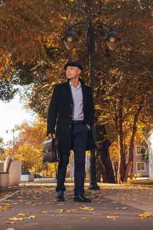 Professional businessman in elegant winter attire against golden autumn backdrop. for business, corporate success, career advancement, and professional lifestyle content.の写真素材