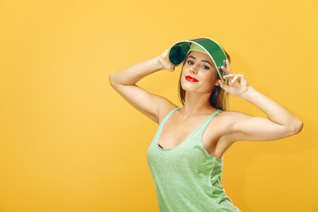 Smiling woman with sun visor hat. for themes such as summer, vacation, leisure, beauty, fashion, accessories, wellness or relaxation.の写真素材