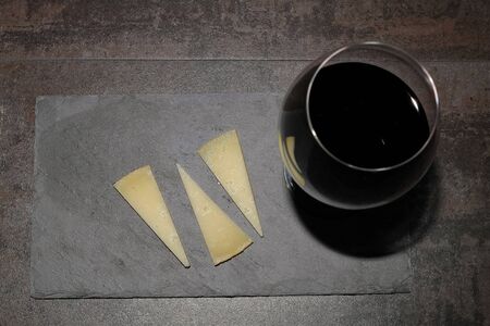 Zenitial image of a slate plate with cheese and a glass of red wineの写真素材