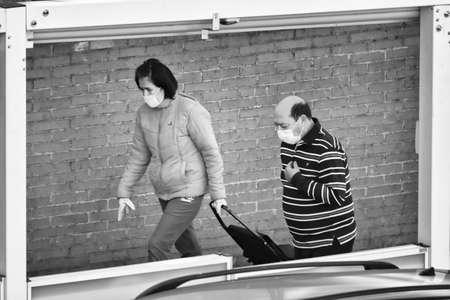 Madrid, Spain, 03-28-2020. Black and white photograph of a man and woman wearing face masks and gloves for the coronavirus. They are going to make the purchaseのeditorial素材