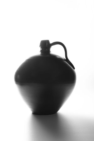 A black clay vase with white backgroundの写真素材