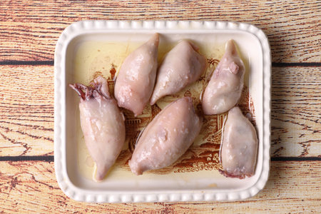 Ration of canned stuffed squid on wooden tableの写真素材