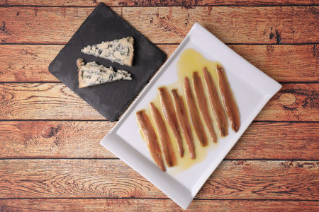Portion of SantoÃ±a anchoas (Cantabrian anchovies) in olive oil with PicÃ³n cheese (Cabrales...