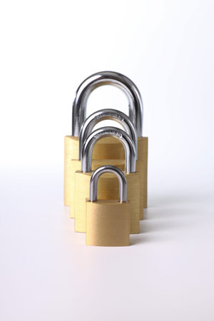 Various brass padlocks of various sizes with white background