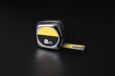 Flexometer or measuring tape on black background