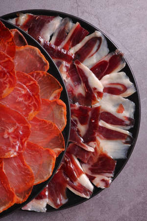 Portion of Iberian ham and 100% acorn-fed loin from Extremadura and 100% acorn-fed Iberian lomoの写真素材