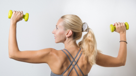 beautiful sporty girl training with dumbbellsの写真素材