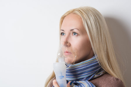 cute girl treated with inhalerの写真素材