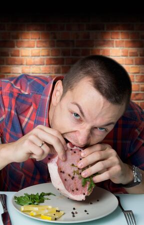 hungry man bites steakの写真素材