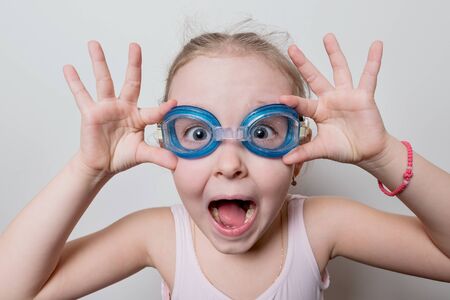 funny little girl with glasses for swimmingの写真素材