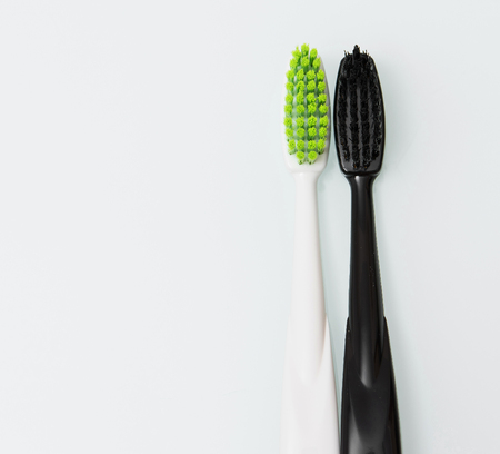 two contrasting toothbrush with toothpaste on white backgroundの写真素材