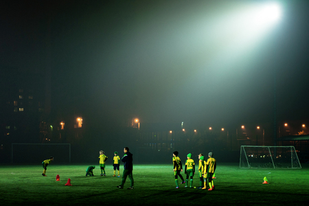 football team trains in the stadium at nightの写真素材