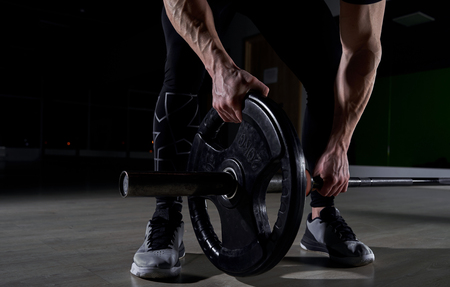 athlete with bare torso trains on a dark backgroundの写真素材