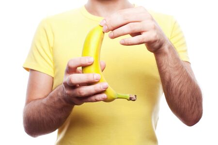 guy holding and opening yellow banana over white background  studio shot の写真素材