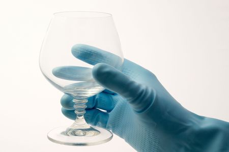 Hand in a rubber glove keeps empty glassの写真素材