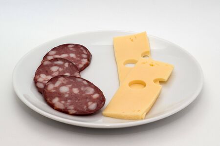 Sausage and cheese on a plate on a white backgroundの写真素材