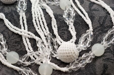 Glass beads on grey scarf on a white backgroundsの写真素材
