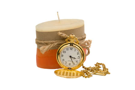 Pocket watches are some of the yellow metal with a candle on a white backgroundの写真素材