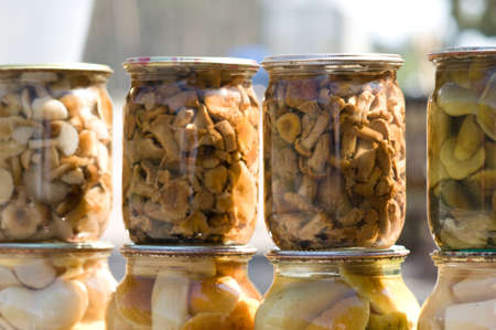 Homemade canned different mushrooms in glass banksの写真素材