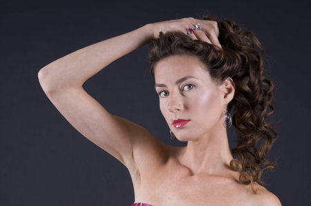 Portrait of a  young beautiful woman on a gray background closeup