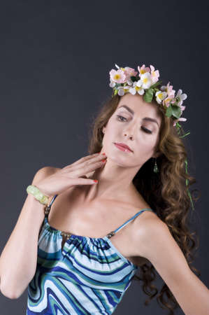 Portrait of a  beautiful girl with flowers in hair on a gray background closeupの写真素材