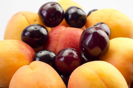 Apricots and cherries on a plate closeupの写真素材