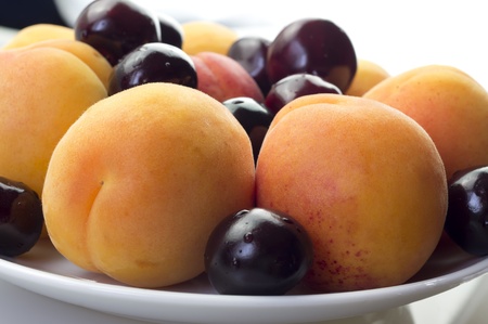 Apricots and cherries on a plate closeupの写真素材