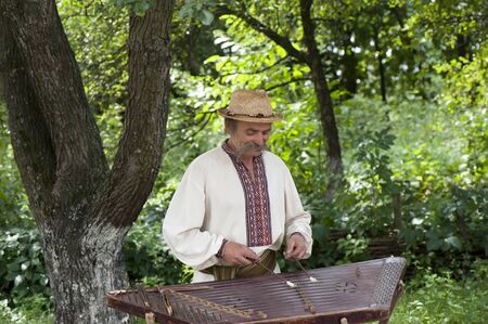A Ukrainian folk musician plays on an old stringed instrument dulcimerのeditorial素材