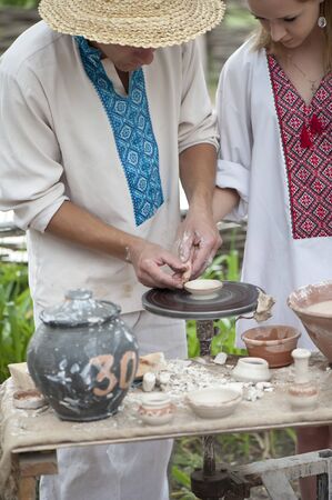 Master Potter teaches young woman working on a Potter's wheelのeditorial素材