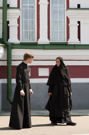 Orthodox monk and nun in black robes next to the Cathedralのeditorial素材