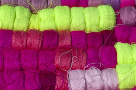 Colored wool yarn in coils closeup, background
