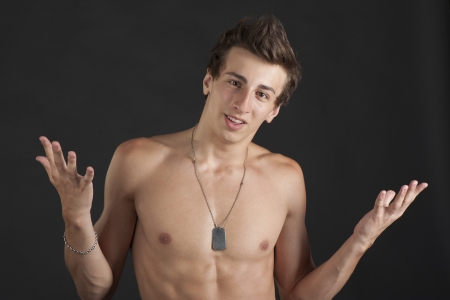 Nice young man with a naked torso in the Studio on a black backgroundの写真素材