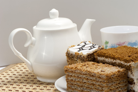 Flaky sweet pastry, tea pot and a cup on the tableの写真素材