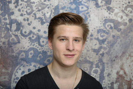 Portrait of a young man in a black t-shirt on an abstract background