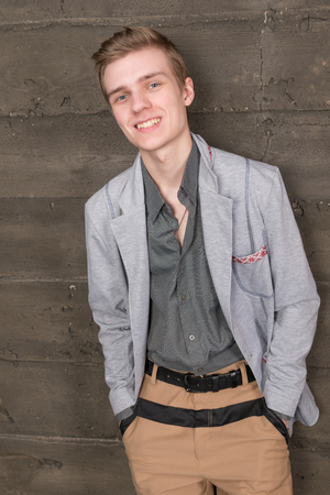 Portrait of a young man in a light jacket on a dark backgroundの写真素材