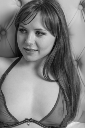 Beautiful young woman with long hair in lingerie on the bed black and whiteの写真素材