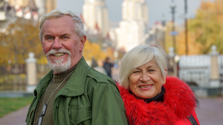 Portrait of a loving elderly couple on a background of autumn cityscapeの写真素材